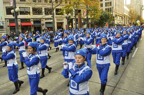 '圖3-4：由上百位法輪功學員組成的、穿著傳統服裝的天國樂團成為遊行的亮點，給兩旁觀眾帶來清新和驚喜。'