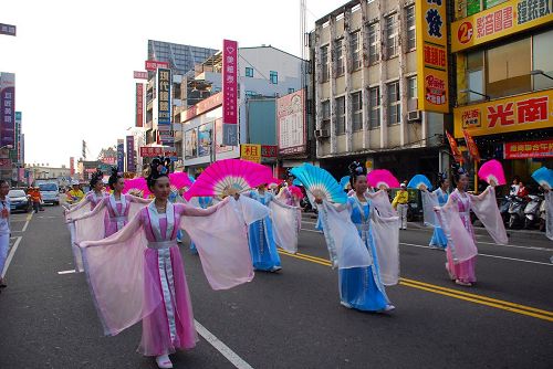 '圖3：法輪功學員組成的仙女隊跟著樂團，沿路贈送紙蓮花，帶來喜慶氣息'