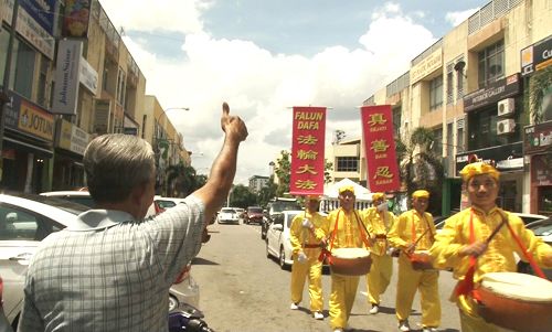 圖11：老居民在路旁豎起拇指，不停的讚歎「好！好！好！」。