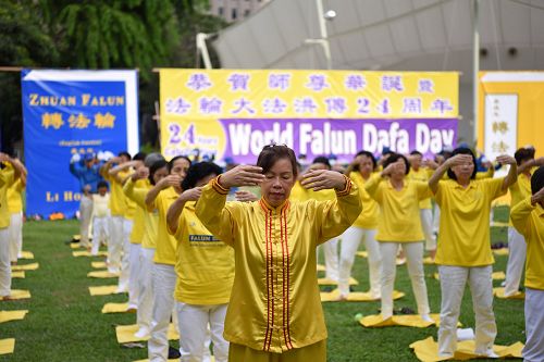 圖2-3：新加坡法輪功學員集體煉功慶祝世界法輪大法日，與民眾分享大法的美好。