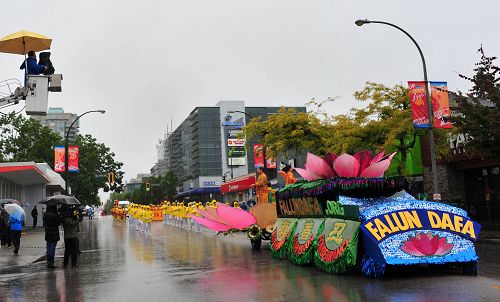 圖4：電視台和觀眾冒雨拍攝法輪功學員遊行隊伍。