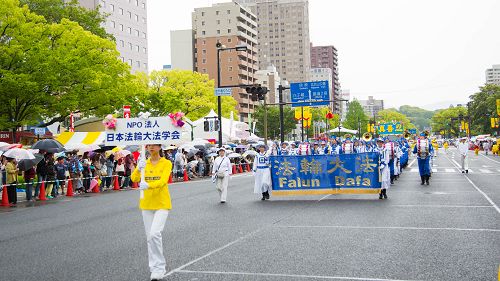 圖1-5：法輪功學員參加廣島鮮花節遊行──鮮花綜合列隊表演。遊行隊伍由氣勢雄壯的天國樂團、花車、祥和的煉功隊等組成，宛如明珠剔透秀於群芳，光彩奪目。