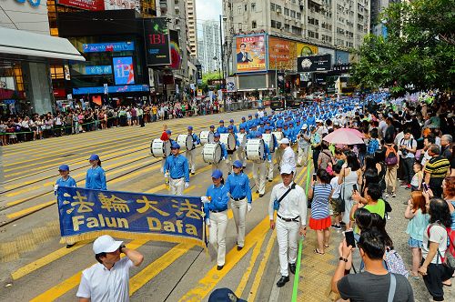 「圖2：天國樂團引領法輪功學員隊伍，遊行從港島區英皇道、軒尼詩道，途經鬧市銅鑼灣、灣仔、中環，最終到西環中聯辦，歷時三個多小時，沿途吸引港民及中西旅客觀看。"