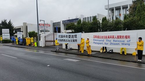 '圖：奧克蘭的法輪功學員打出「抗議中共耍流氓，抗議剪毀王治文護照」以及「立即還王治文赴美與親人團聚的權利」等橫幅，並在舒緩的音樂中煉功，無聲地表達抗議。'