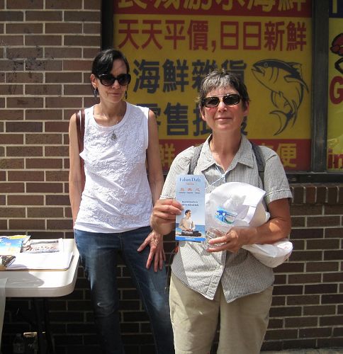 '圖2：來自西雅圖市的華盛頓大學電影學教授Claudia Gorbman女士（右）在「反強制活摘器官」徵簽表上簽名後留影'