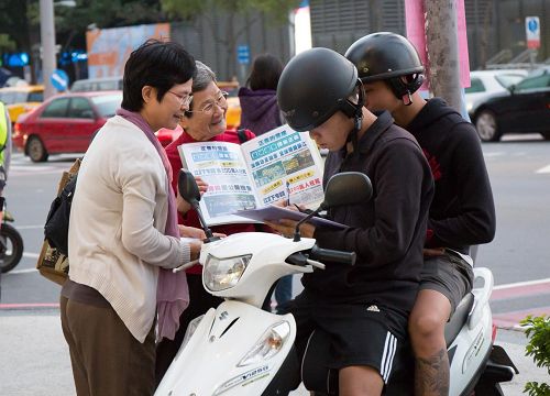 '圖2：洵姨（左二）每天到景點發傳單、舉真相展板，讓遊客明白「法輪大法好」。'