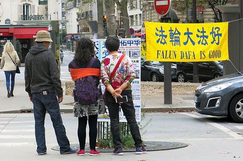 '圖3：巴黎埃菲爾鐵塔下的退黨點上，大陸遊客認真觀看真相展板。'