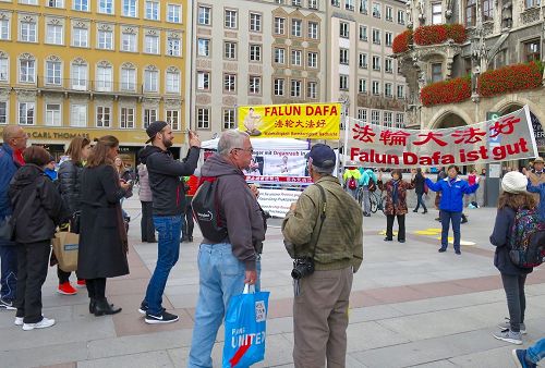 '圖1：法輪功學員在瑪琳廣場展示功法及揭露中共活摘器官的橫幅吸引了民眾觀看。'