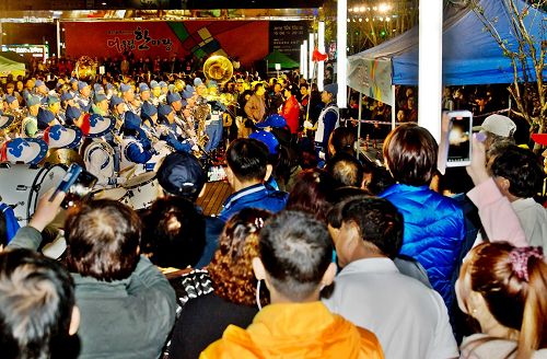 '圖5：天國樂團和法輪功功法演示隊面向審查團和觀眾進行表演，觀眾紛紛拿出手機拍照、錄像。'