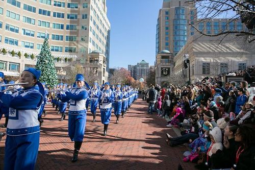 '圖1～5：二零一七年十一月二十四日，美國弗吉尼亞州瑞思頓（Reston）鎮舉辦節日遊行，有約一百五十名法輪功學員組成的天國樂團首次參加。遊行主辦方表示感謝，兩旁觀眾歡迎。維州瑞斯頓市民 Sarah Happel說：「他們的服裝、帽子，一切都那麼好，音樂也很動聽。真是非常棒﹗」'