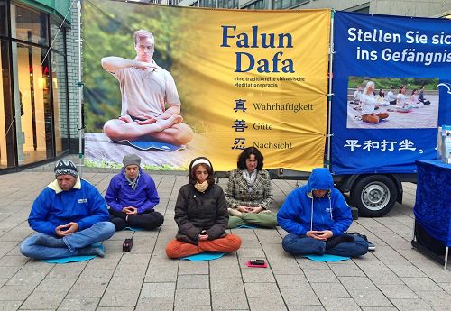 '圖1：二零一七年十一月四日，法輪功學員在漢堡市中心舉辦信息日活動，向民眾介紹法輪功。圖為法輪功學員正在演示第五套功法──神通加持法。'