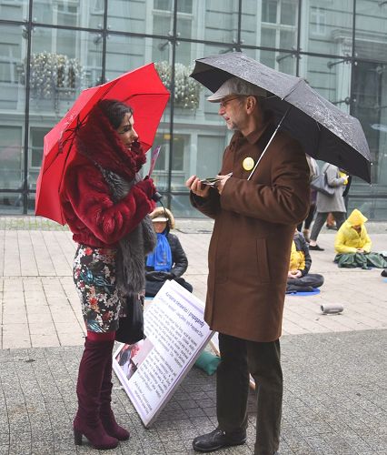 圖4：波蘭法輪功學員在波茲南市中心冒雨講真相 徵簽反迫害