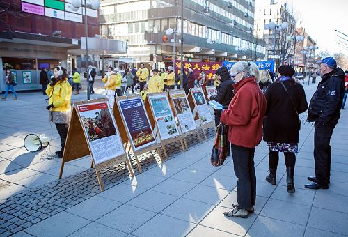 '圖5：在南泰利耶市中心廣場，民眾觀看展板，了解法輪功真相。'