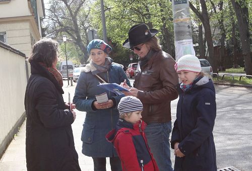 '圖4：民眾想了解法輪功反迫害真相，人們簽名制止中共對法輪功學員的迫害。'