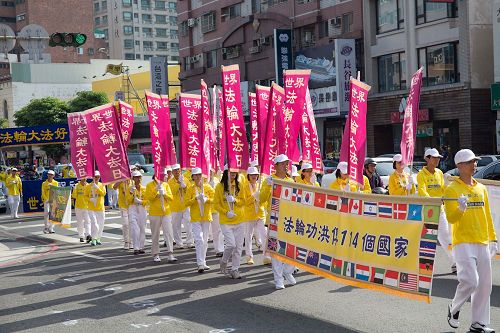 '圖6：二零一七年高雄法輪功學員慶祝即將來臨的「五一三世界法輪大法日」集會遊行，學員們精神抖擻地舉著旗幟和橫幅。'