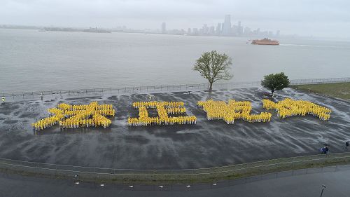 圖1：慶祝「世界法輪大法日」，法輪功學員冒雨排出「法正乾坤」 四個大字。