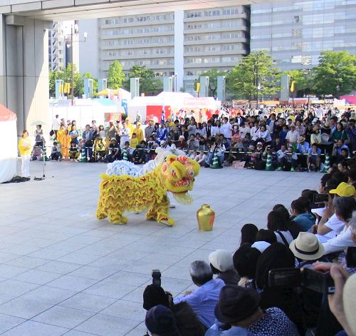 '圖4～7：在演出廣場進行表演的天國樂團、打腰鼓、獅子舞和法輪功五套功法演示，吸引了很多觀眾（圖）'