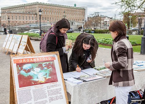 了解真相後的人們在反活摘器官的簽名冊上簽名，支持法輪功學員反迫害。