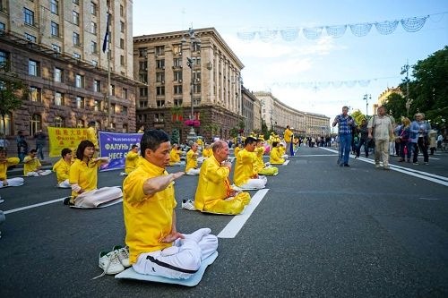 '圖2～3：法輪功學員集體煉功的祥和場面，令過往行人矚目。'