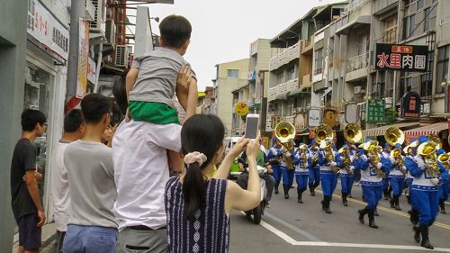 '圖3：很多市民拿手機爭相對著行進中的天國樂團拍照。'