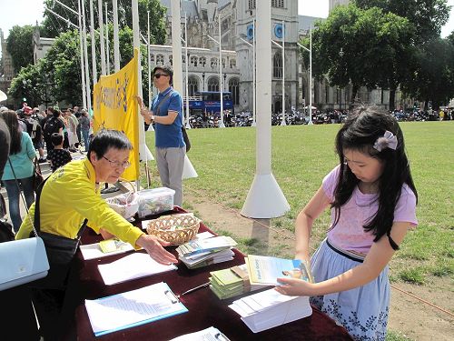 '圖4：二零一七年七月十八日，小法童（右一）和爸爸一起參加在英國議會大廈前參加法輪功學員講真相反迫害活動'