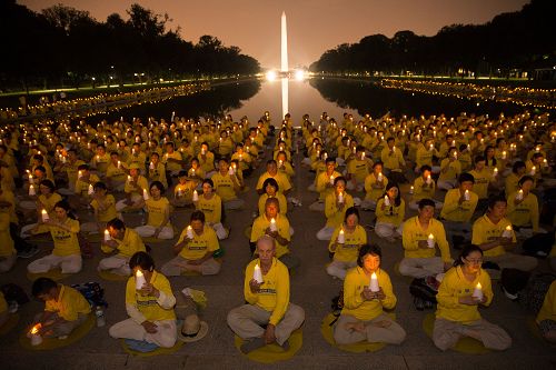 '圖1：二零一七年七月二十日晚，來自美東地區的部份法輪功學員在美國首都華盛頓林肯紀念堂前點燃燭光，悼念過去十八年來被中共迫害致死的同修，呼籲立即停止迫害。'