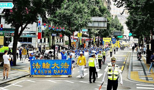 '圖6：韓國警察為法輪功遊行隊伍開道。'