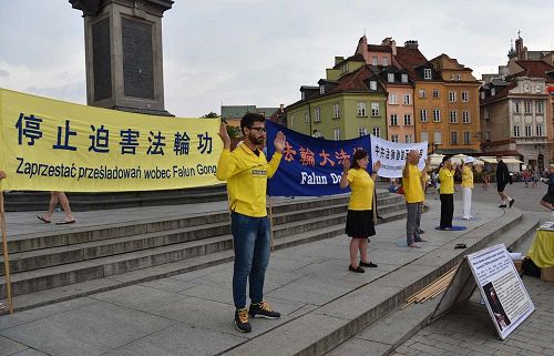 '圖2～3：波蘭法輪功學員在華沙古城中心廣場向民眾展示法輪功功法'