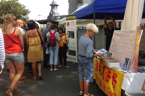 '法輪功學員在迪納爾（Dinard）集市上介紹法輪功真相'