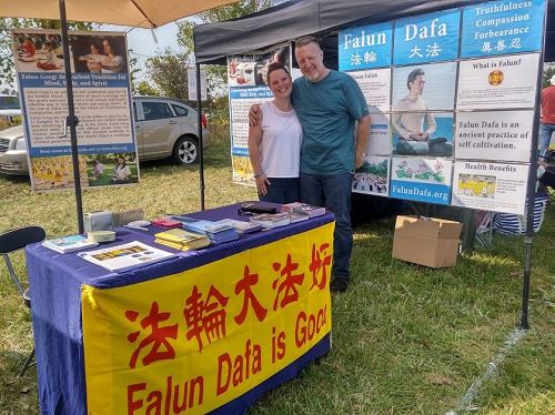 '圖4：汽車展上法輪功展位旁邊的攤位夫婦開心的在法輪功展位留念'