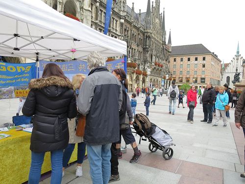 '圖1～6：二零一七年九月二日，法輪功學員在德國慕尼黑的瑪琳廣場（Marienplatz）舉辦講真相活動，不少過往民眾駐足了解真相，並簽名譴責中共活摘法輪功學員器官。'