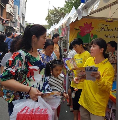 '圖1：法輪功學員在文化節上向華人講真相'