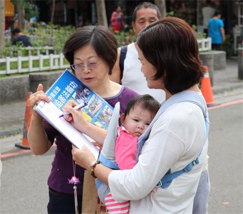 '圖6～7：不論是主動到服務台或透過法輪功學員講真相，遊客不分男女老少，紛紛義不容辭地加入訴江徵簽。'