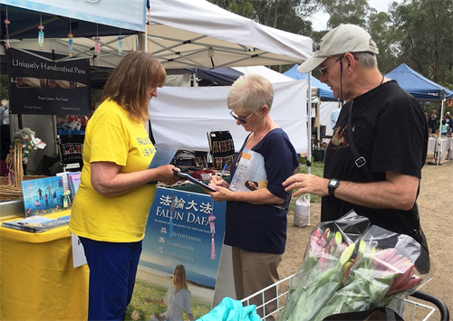 '圖4：十二月十五日，亞拉河畔沃倫戴特（Warrandyte）區的聖誕市集上，得知真相的人們在制止迫害的徵簽表上簽名。'