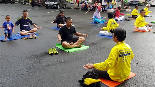 '圖4：縮影公園裏，遊客學煉法輪功'