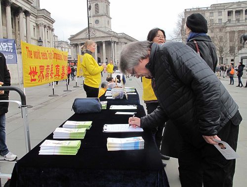 圖6： 二零一八年三月二十四日，在倫敦特拉法加廣場，來倫敦遊玩的蘇格蘭教師理查德（Richard）簽名反對中共迫害。