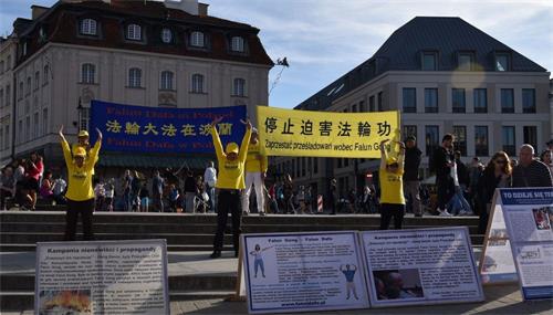 '圖6-8：波蘭法輪功學員在華沙古城向遊客市民展示法輪功功法'