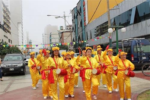 '圖1～3：法輪功學員隊伍從指定地點──自由廣場出發，打開「法輪大法好」的橫幅，敲著腰鼓，向圖帕克阿馬魯廣場行徑，向沿途路人和商家傳播法輪大法的美好。'