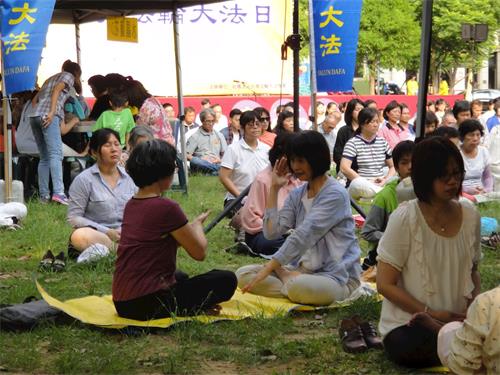 '圖7～8：現場有學員義務教功，不少民眾學煉法輪功。'