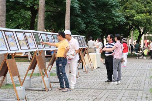 '圖10～11：路過的民眾駐足在展板面前了解法輪功真相。'