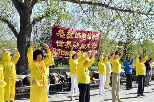 '圖1：卡爾加裏法輪功學員在王子島公園集體煉功，慶祝法輪大法日'