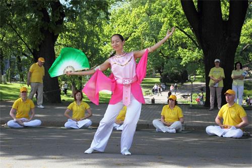 '圖6：法輪功學員在跳扇子舞'