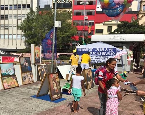 '圖11：在聖保羅市，法輪功學員於五月十三日這天，在亞裔區熱鬧地段設真相展位，傳播大法的真相。'