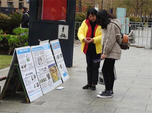 '圖3：法輪功學員給中國留學生詳細講解自焚慢鏡頭分析，認清中共欺騙伎倆的大學生欣然三退。'