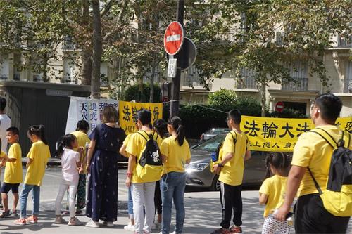 '圖3：一隊大陸來的學生旅遊團正在等紅燈時觀看真相展板'