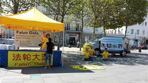 '圖：二零一八年八月十七日，法輪功學員在奧地利南部克恩頓州（Kärnten）的首府克拉根福特（Klagenfurt）市政廳前「新廣場」上，設立真相點，向過往民眾傳播法輪功的真相。'