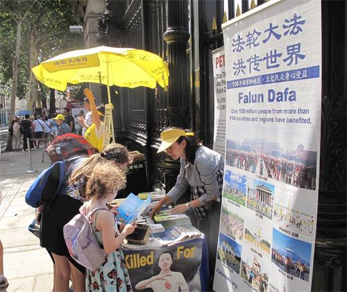 '圖1：二零一八年八月四日，法輪功學員在大英博物館正門外煉功、發真相傳單、講真相、徵簽反迫害。'