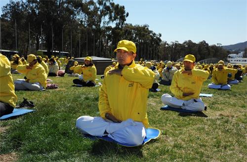 '圖2～3：二零一八年九月十七日和十八日，法輪功學員在澳大利亞首都堪培拉舉行了大型講真相活動，圖為法輪功學員在澳洲聯邦國會大廈前草坪集體煉功。'