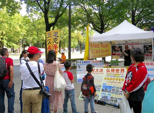 '圖1：大陸遊客閱讀法輪功真相展板。'