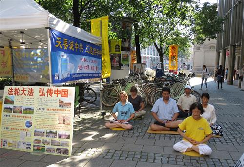 '圖3：在大巴遊客必經之路，法輪功學員展示功法'